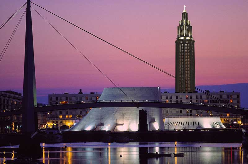 Vue de la ville du Havre la nuit, monuments architecturaux éclairés contre un ciel violet sombre