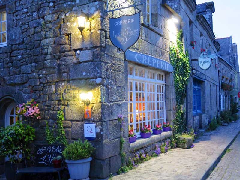 Crêperie, crêperie, restaurant dans une rue pavée de Locronan, Bretagne, au crépuscule