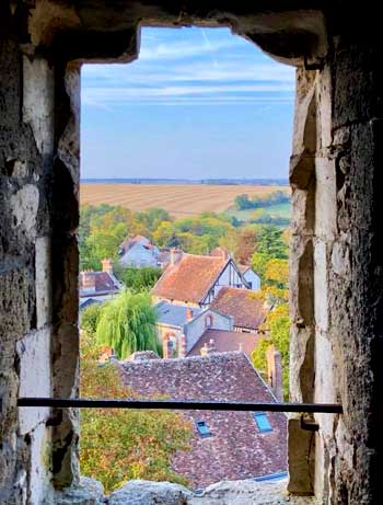 Vue à travers une ancienne fenêtre en pierre sur la campagne et le village de Provins