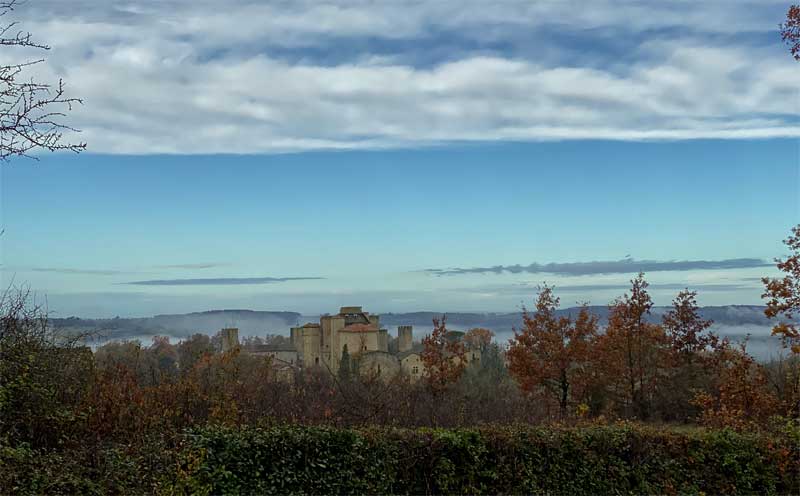 Vue sur la campagne d'une petite ville fortifiée, c'est des tourelles et des tours au sommet d'une petite colline