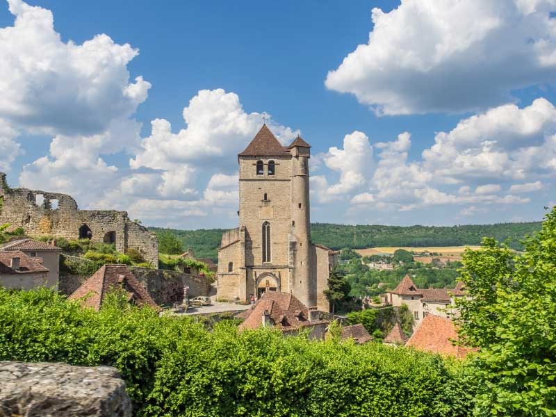 Ancienne église au sommet d'une colline à côté des murs en ruine d'un château, St-Cirq-Lapopie