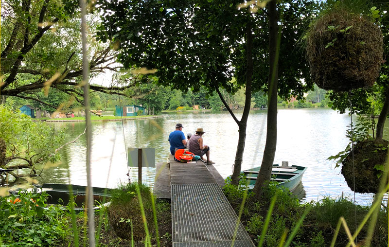 Personnes bénéficiant d'un pique-nique sur un ponton au bord d'un lac à Amiens 