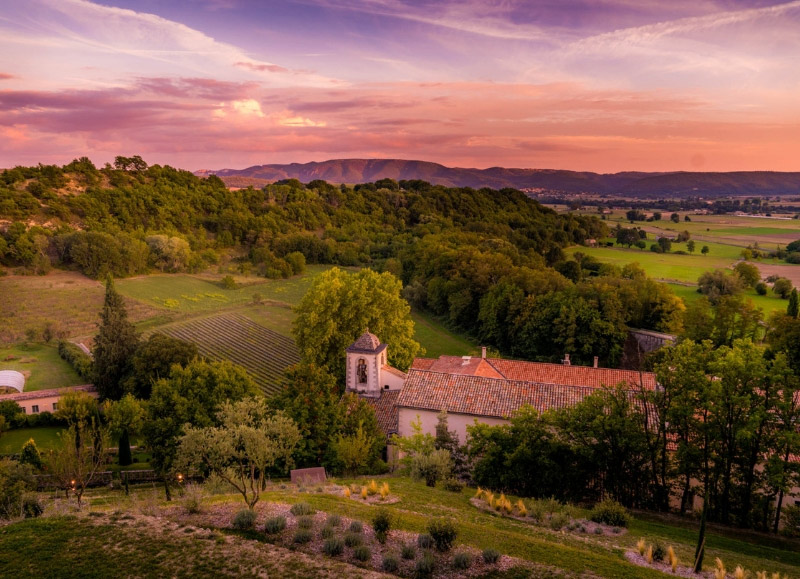 Coucher de soleil en Provence, un ciel profondément rose et violet sur un champ de vignes et de forêt