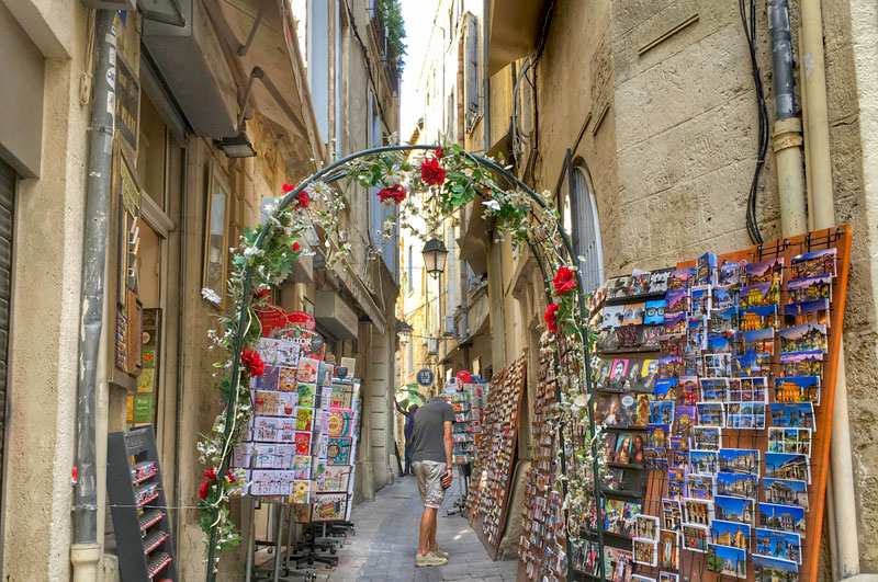 A narrow street lined with ancient buildings made into quirky, colourful shops in Montpellier's old town